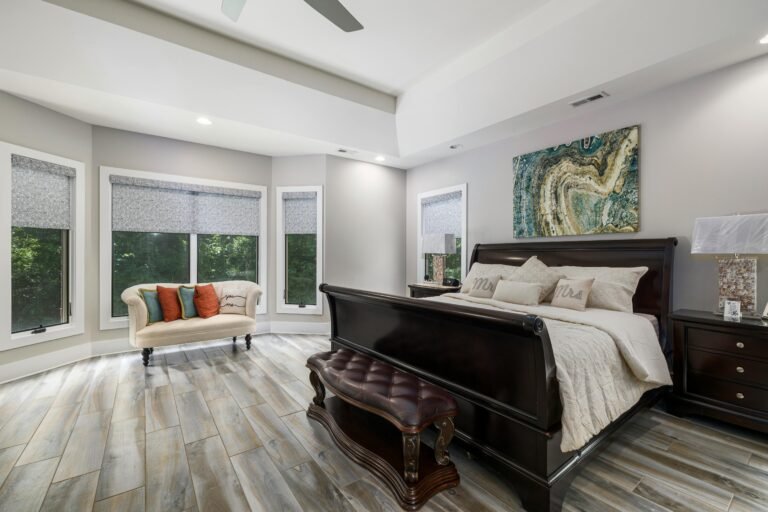 Sophisticated modern bedroom featuring luxurious furniture, large windows, and stylish decor with ample natural light.